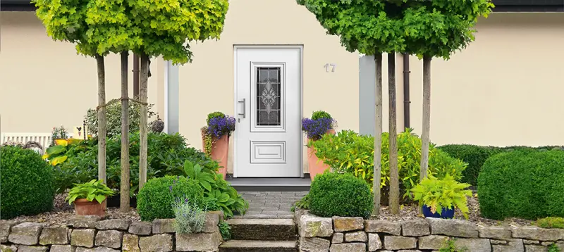 Weiße Haustür mit Zierglas im Landhausstil mit Vorgarten